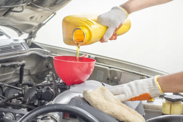 Meccanico auto versando nuovo olio al motore . — Foto Stock