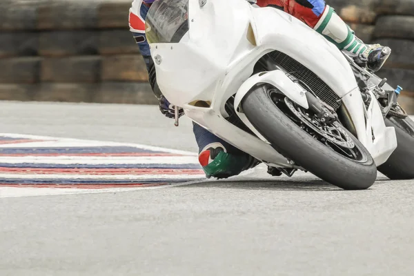 Piloto de bicicleta de carreras se inclina en una esquina rápida en la pista —  Fotos de Stock