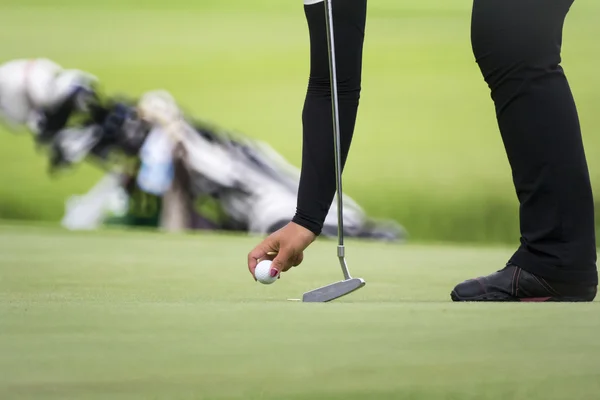 Жінка-гольф відзначає свою позицію м'яча на зеленому — стокове фото
