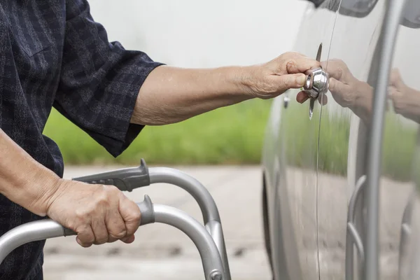 Äldre kvinna med en rullator på parkeringen — Stockfoto