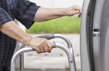 araba parkında bir yürüteç kullanan kadın kıdemli