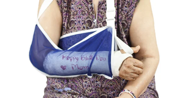 Mulher idosa com um braço quebrado em um gesso — Fotografia de Stock