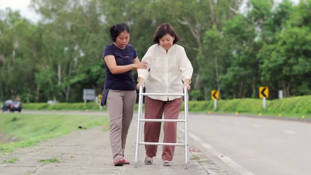 Mujer mayor usando un andador de la calle cruzada — Vídeo de stock