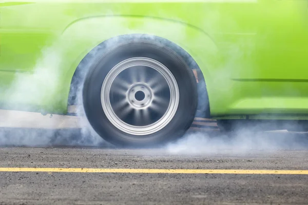 Carro de corrida queima borracha fora de seus pneus em preparação para a corrida — Fotografia de Stock