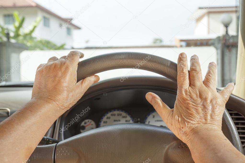 Senior woman driving a car in town.