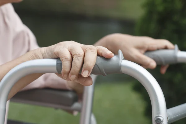 Mãos de idosos em um andador . — Fotografia de Stock