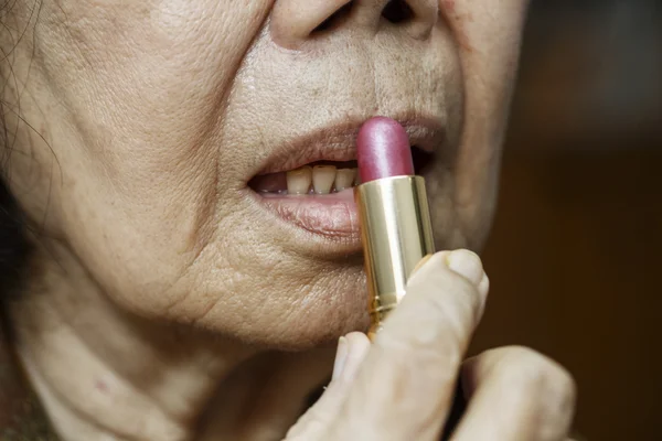 Elderly asian woman applied lipstick — Stock Photo, Image