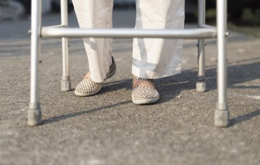 kadın kıdemli bir walker kullanarak çapraz sokak.