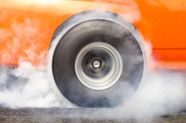 Drag racing car burns rubber off its tires clipart