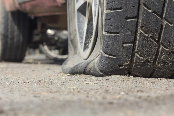 Lekke band van de auto op weg — Stockfoto