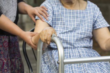 kadın kıdemli oturma kullanım caregiver Walker'la