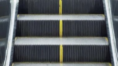 Metro altgeçidine doğru giden devasa metal yürüyen merdiven. İnsansız sayısız basamak. Yol boyunca yürüyen merdiven..