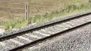 Gün batımında demiryolu rayları çelik raylar ve çakıl balast üzerinde ahşap yataklar. Perspektif çizgileri ileri gidiyor. Ulaşım altyapısı detayı. Seyahat ve seyahat kavramı