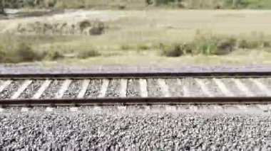 Gün batımında demiryolu rayları çelik raylar ve çakıl balast üzerinde ahşap yataklar. Perspektif çizgileri ileri gidiyor. Ulaşım altyapısı detayı. Seyahat ve seyahat kavramı