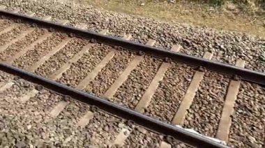 Gün batımında demiryolu rayları çelik raylar ve çakıl balast üzerinde ahşap yataklar. Perspektif çizgileri ileri gidiyor. Ulaşım altyapısı detayı. Seyahat ve seyahat kavramı