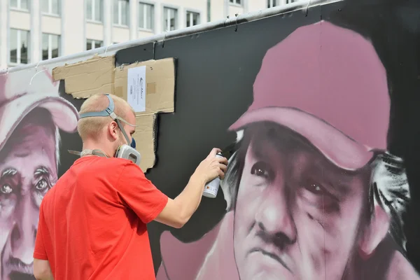 Unidentified graffitist paints on a temporary wall — Stock Photo, Image