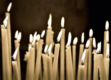 Firing candles on dark wall background