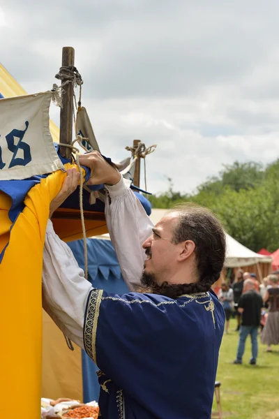 Unidentified participant in medieval costume installs his tent in medieval camping of knights during Fete Medievale in parc of Deurne — Stock Photo, Image