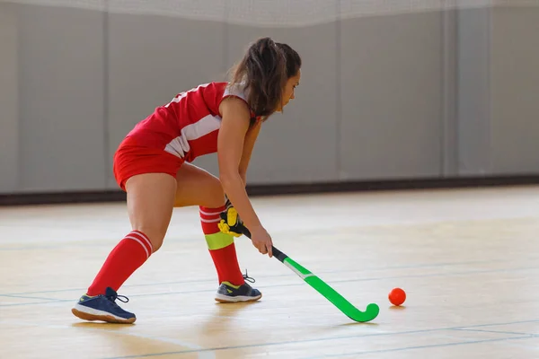 Jonge vrouw speler in aanval bij indoor hockey wedstrijd — Stockfoto