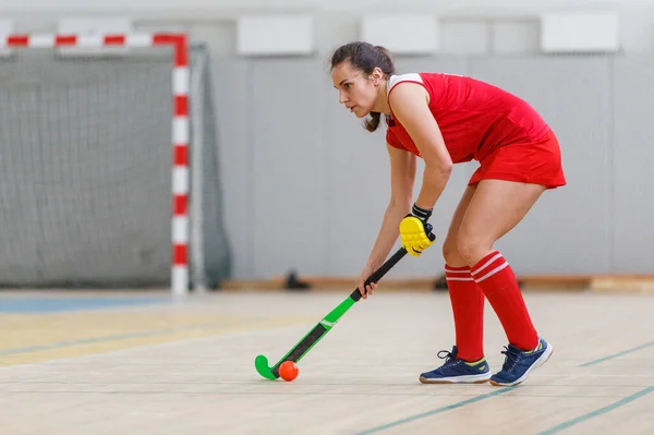 Jonge vrouw speler in aanval bij indoor hockey wedstrijd — Stockfoto
