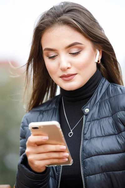 Young beautiful woman using smartphone in the park — Stock Photo, Image