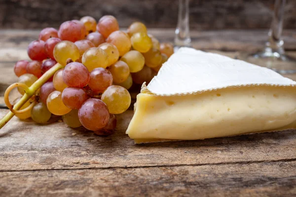 Bunch of grape with brie cheese on wooden table — Stock Photo, Image