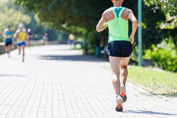 Giovane uomo in forma che corre nel parco il giorno d'estate — Foto Stock