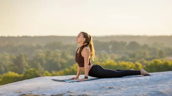 Junge Fitness-Frau macht Yoga im Freien bei Sonnenuntergang — Stockfoto