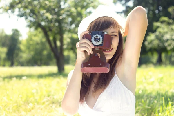 Mujer joven posando con una vieja cámara de cine en el parque de verano — Foto de Stock