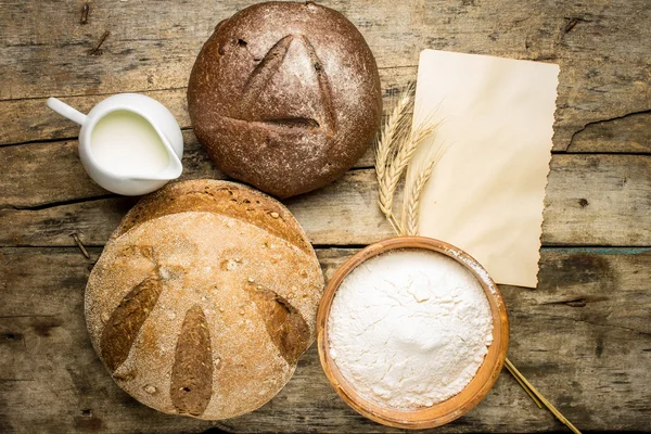 Different loafs of bread with bakery ingredients — Stock Photo, Image