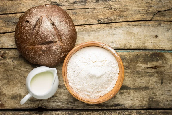 Bakery ingredients with loaf of bread — Stock Photo, Image