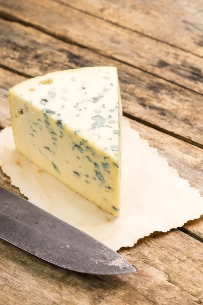 Blue cheese with old rural knife on wooden table. — Stock Photo, Image