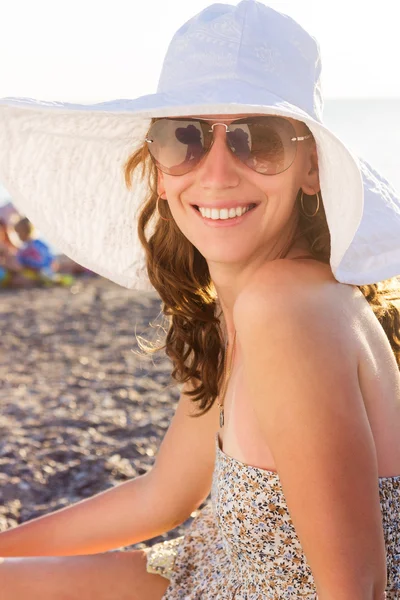 Молодая улыбающаяся женщина на пляже у моря — стоковое фото