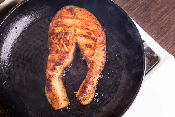 Roasting salmon steak on grill pan — Stock Photo, Image