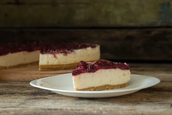 Wedge of cheesecake on the wooden table — Stock Photo, Image