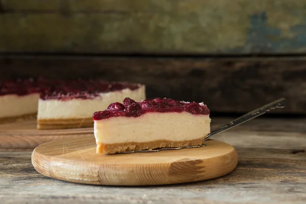 Wedge of cheesecake on the wooden table — Stock Photo, Image
