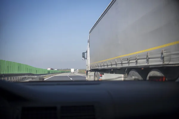 Condução de um carro na estrada com caminhão — Fotografia de Stock