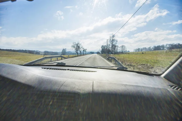 Guidare una macchina in città con un forte riflesso del sole — Foto Stock