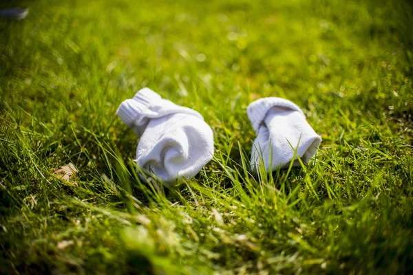 Bílé ponožky na zelené trávě — Stock fotografie