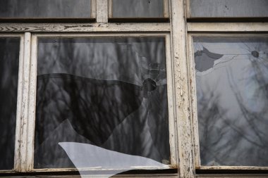 clounding gökyüzünü yansıtan kırık cam pencere