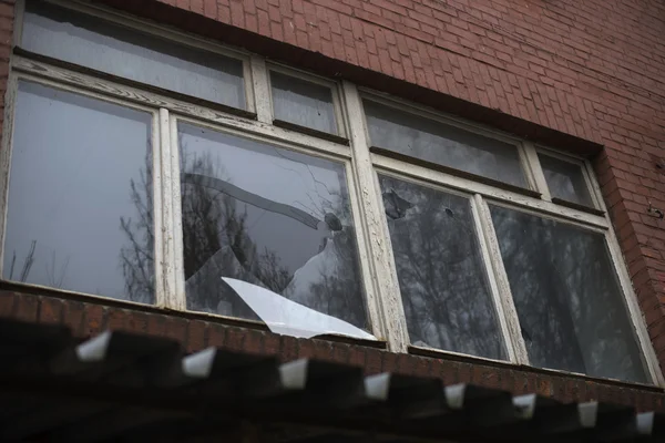 Rozbité sklo okna odrážející clounding sky — Stock fotografie