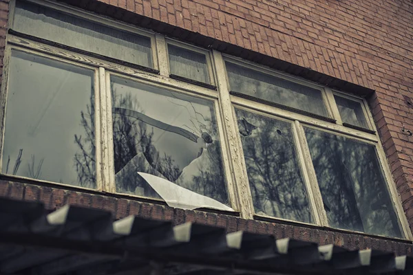 Ventana de cristal roto que refleja el cielo clounding — Foto de Stock