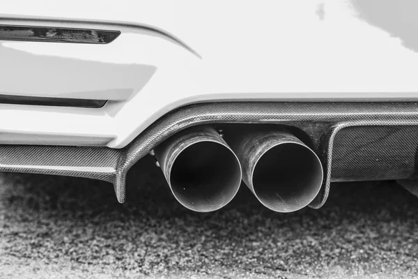 Двойные выхлопные трубы современного спортивного автомобиля, черно-белые — стоковое фото
