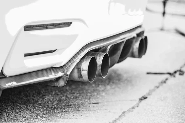 Tubos de escape dobles de un coche deportivo moderno, blanco y negro — Foto de Stock