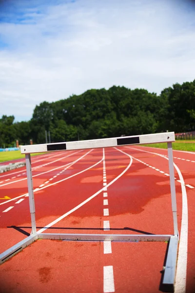 Atletik çalıştıran kırmızı izlemek engel, kötü hava koşulları, ıslak — Stok fotoğraf