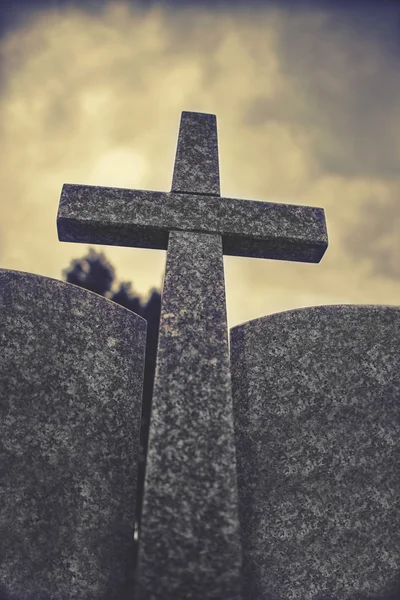 Cruz de pedra contra o céu nublado dramático, efeito vintage — Fotografia de Stock