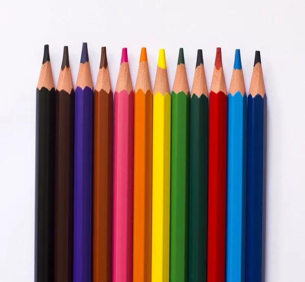Красочные карандаши на белом бумажном фоне — стоковое фото