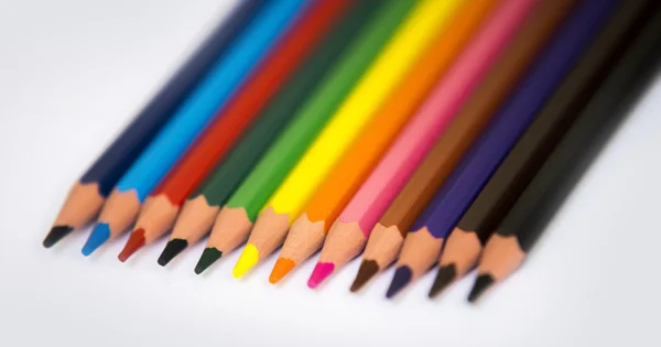 Lápis coloridos isolados em um fundo de livro branco, foco seletivo — Fotografia de Stock