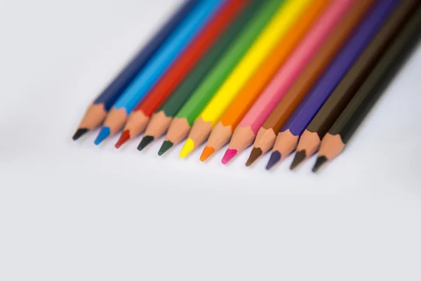 Fargerike blyanter isolert på bakgrunn av hvitt papir, selektivt fokus – stockfoto