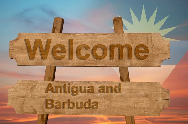 Bienvenido a Antigua y Barbuda cantar sobre fondo de madera con la mezcla de la bandera nacional — Foto de Stock